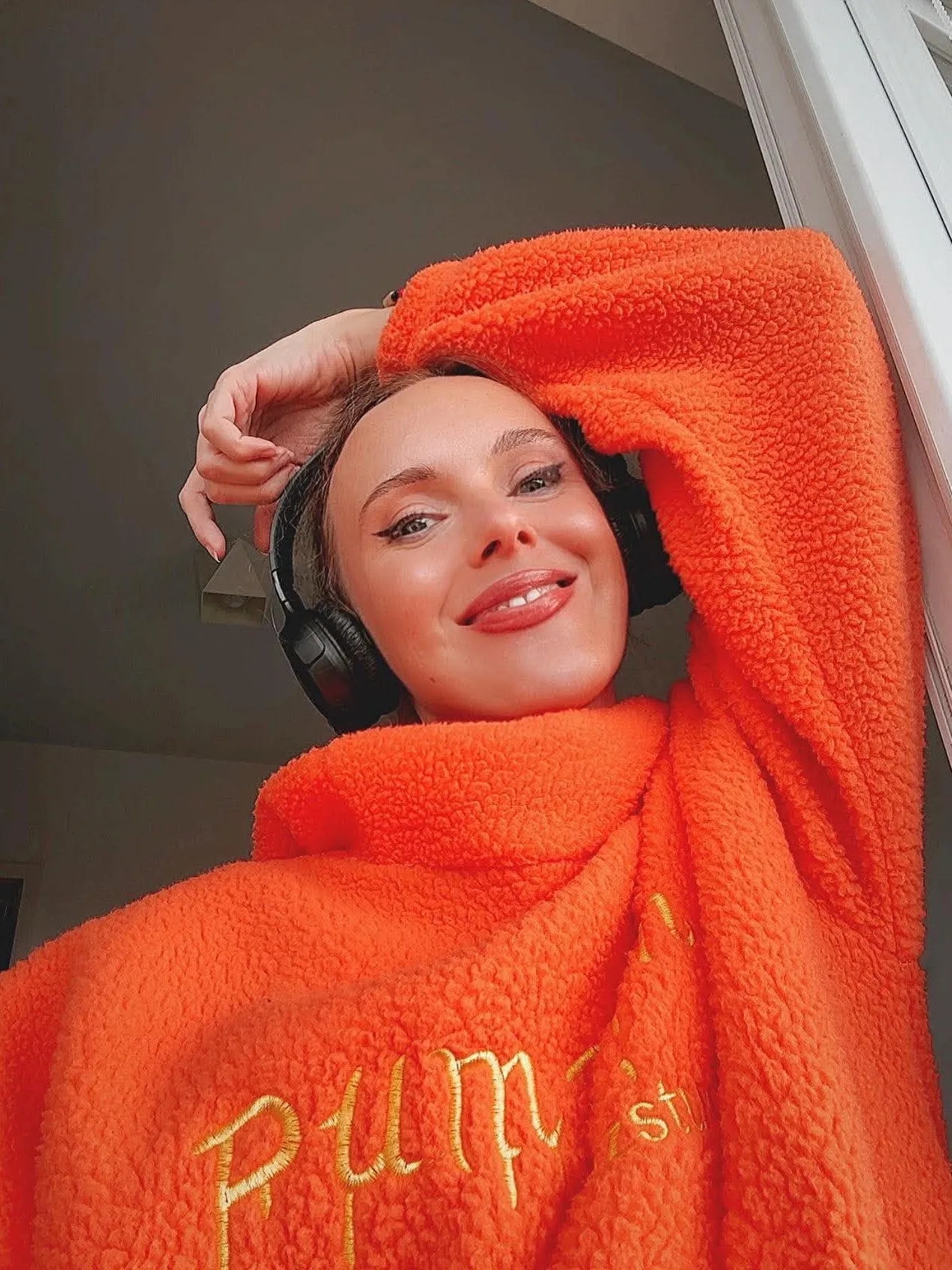 Me in an orange pumpkin hoodie with headphones on